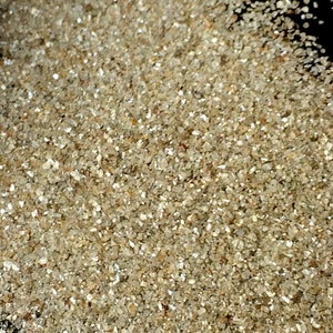 May include: A close-up view of a pile of small, clear, and sparkly diamonds. The diamonds are various sizes and shapes, and they are all very shiny.