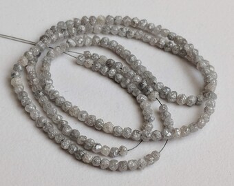 May include: A strand of grey rough diamond beads. The beads are faceted and have a natural, unpolished look.