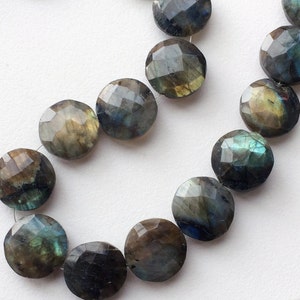 May include: A strand of round, faceted labradorite beads in shades of green, blue, and gold. The beads are strung on a clear thread.