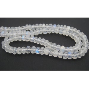 Peut inclure: Un collier de perles de pierre de lune blanche avec un &eacute;clat iridescent. Les perles sont facett&eacute;es et ont une forme l&eacute;g&egrave;rement irr&eacute;guli&egrave;re.