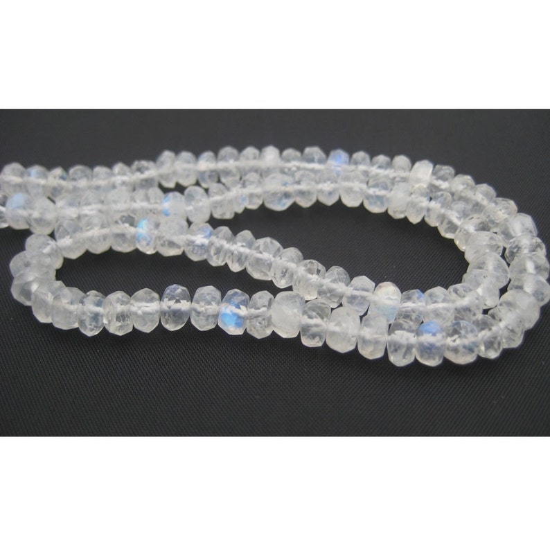 Peut inclure: Un collier de perles de pierre de lune blanche avec un &eacute;clat iridescent. Les perles sont facett&eacute;es et ont une forme l&eacute;g&egrave;rement irr&eacute;guli&egrave;re.