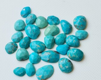 Puede incluir: Una colección de cabujones de turquesa, cada uno con una forma y un patrón únicos. Las piedras son de un color azul verdoso vibrante y tienen un acabado liso y pulido.