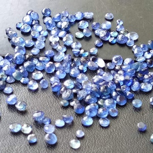 May include: A scattering of small, faceted, blue gemstones. The stones are oval-shaped and have a slightly irregular, natural appearance.