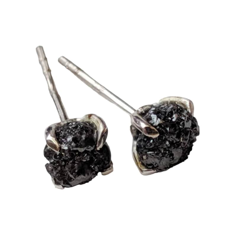 May include: A pair of silver stud earrings with black rough diamond stones.