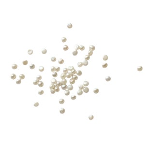 May include: A scattering of white pearl beads on a white background.