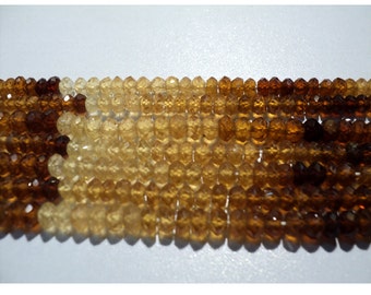 May include: A strand of faceted gemstone beads in shades of brown, yellow, and orange. The beads are round and have a smooth, polished finish.
