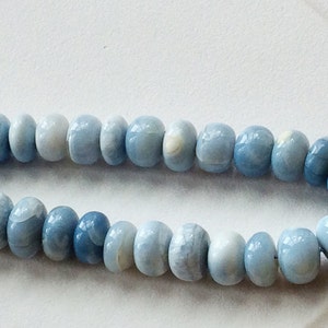 May include: A strand of light blue opal beads. The beads are round and have a smooth, polished finish.