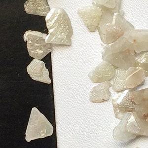 May include: A collection of small, translucent, white, and light green crystals. The crystals are irregularly shaped and have a rough, natural texture.