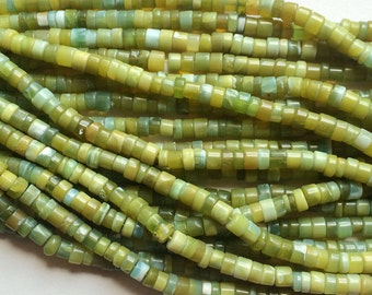 May include: A strand of green and yellow gemstone beads. The beads are small and round, and they have a smooth, polished finish.