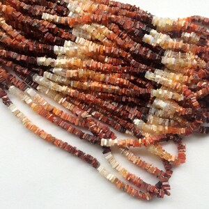 May include: A strand of red, orange, and white gemstone beads. The beads are square and have a rough, natural finish.