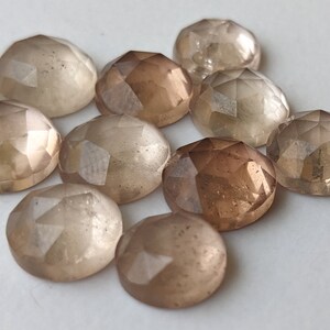 Puede incluir: Diez cabujones de piedra preciosa facetados en tonos de marr&oacute;n claro y beige. Las piedras son redondas y tienen un acabado liso y pulido.