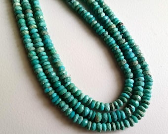 May include: A strand of turquoise beads, featuring a faceted, round shape. The beads are a vibrant blue-green color.