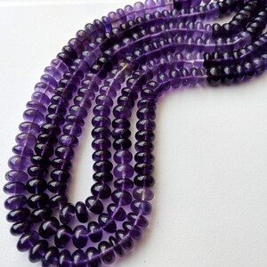 May include: A strand of purple amethyst beads, with multiple strands of beads layered on top of each other. The beads are round and have a smooth, polished finish.