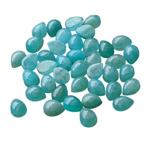 May include: A collection of loose, teardrop-shaped gemstones in a vibrant turquoise-blue color. Each stone features a smooth, polished surface with a rounded top and a pointed base, displaying subtle variations in opacity and internal texture.
