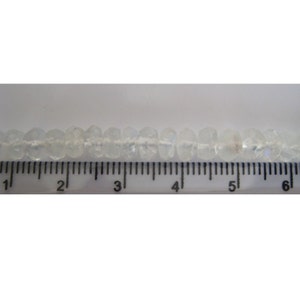 Peut inclure: Un brin de perles facett&eacute;es transparentes mesurant environ 15 cm de long. Les perles sont enfil&eacute;es sur un fil blanc et sont espac&eacute;es uniform&eacute;ment.