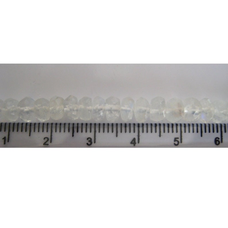 Peut inclure: Un brin de perles facett&eacute;es transparentes mesurant environ 15 cm de long. Les perles sont enfil&eacute;es sur un fil blanc et sont espac&eacute;es uniform&eacute;ment.
