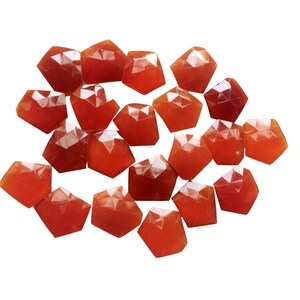 Puede incluir: Una colecci&oacute;n de 18 piedras preciosas de cornalina facetadas, cada una con una forma y un tama&ntilde;o &uacute;nicos. Las piedras son de color rojo anaranjado intenso y tienen un acabado liso y pulido.