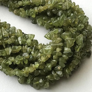 以下が含まれることがあります： 緑色の宝石のチップ、おそらくペリドットが円形に並んだストランド。チップは不規則な形をしていて、わずかに半透明に見えます。