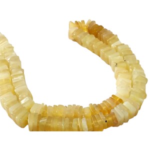 May include: A strand of yellow opal beads, each bead is a rectangular shape with a slightly rounded edge. The beads are strung together to form a necklace.