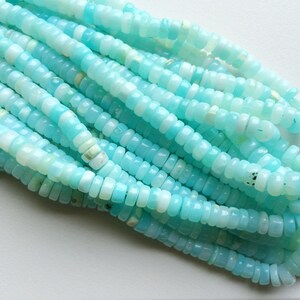 May include: A strand of light blue opal beads. The beads are small and round, and they have a slightly iridescent sheen.
