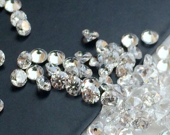 May include: A close-up of a group of small, round, clear diamonds on a black surface.
