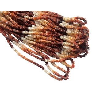 May include: A strand of square-shaped, red, orange, and white gemstone beads. The beads are approximately 4mm in size and have a natural, irregular shape.