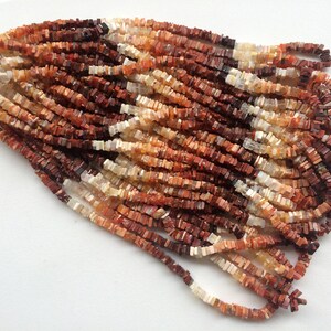 May include: A strand of multi-colored gemstone beads. The beads are square shaped and have a mix of red, orange, and white colors.