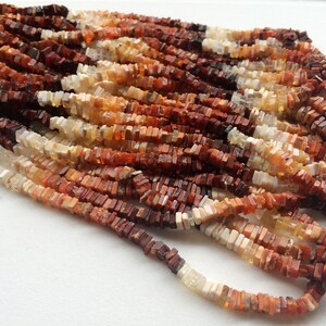 May include: A strand of multi-colored, square-shaped opal beads. The beads are a mix of white, orange, and brown.