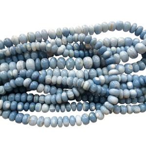May include: A strand of light blue and white banded agate beads. The beads are oval shaped and have a smooth, polished finish.