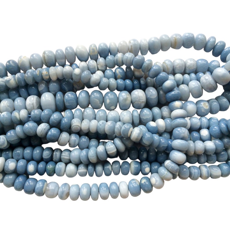 May include: A strand of light blue and white banded agate beads. The beads are oval shaped and have a smooth, polished finish.