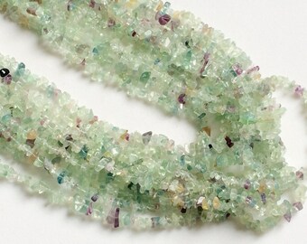 May include: A strand of light green, chip-shaped fluorite beads. The beads are irregular in shape and have a translucent appearance.