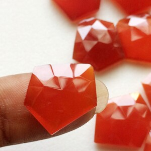 Puede incluir: Una colecci&oacute;n de piedras preciosas de cornalina facetadas en una variedad de tama&ntilde;os y formas. Las piedras preciosas son de color naranja intenso y tienen un acabado brillante.