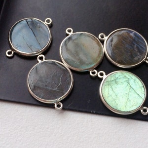 May include: Five round silver-toned pendants with a variety of iridescent blue and green labradorite stones.