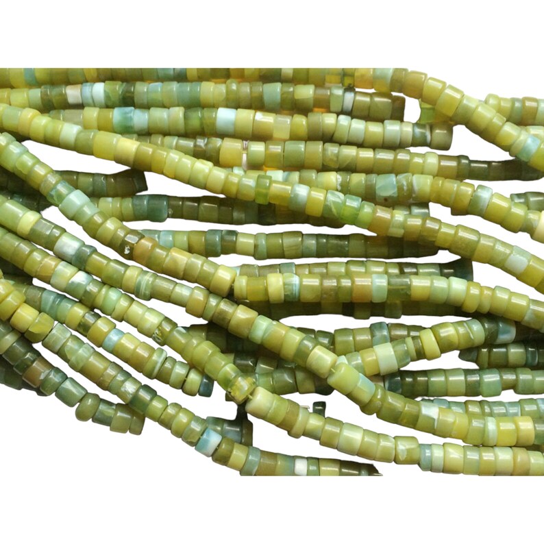May include: A strand of green and yellow jade beads, each bead is a small cylinder with a slightly rounded shape.