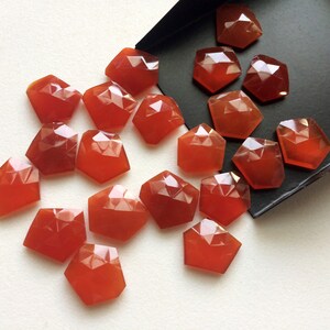 Puede incluir: Una colecci&oacute;n de 20 piedras de cornalina facetadas de diferentes tama&ntilde;os y formas. Las piedras son de color rojo anaranjado intenso y tienen un acabado pulido y brillante.
