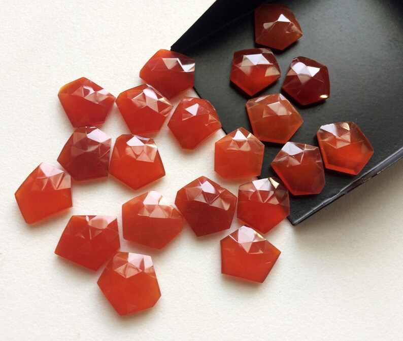 Puede incluir: Una colecci&oacute;n de 20 piedras de cornalina facetadas de diferentes tama&ntilde;os y formas. Las piedras son de color rojo anaranjado intenso y tienen un acabado pulido y brillante.