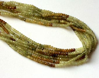 Peut inclure: Un brin de perles de pierres précieuses vertes et brunes. Les perles sont petites et rondes, et elles sont enfilées sur un fil transparent.