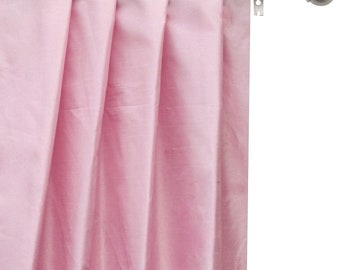 May include: A pink curtain with pleats hangs from a silver curtain rod with a finial.