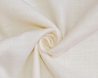 May include: A close-up of a white fabric with a textured weave. The fabric is folded and twisted, creating a soft, organic shape.