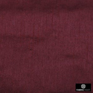 May include: A close-up of a deep burgundy fabric with a subtle texture. The fabric has a smooth, even surface and a rich, dark color.