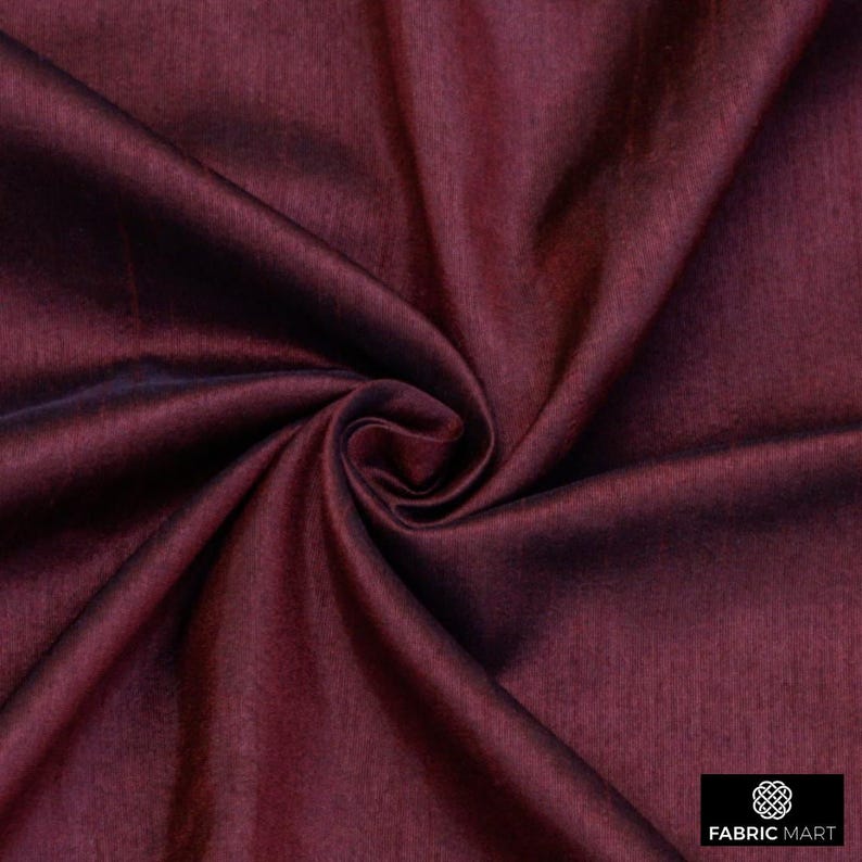May include: Close-up of a deep burgundy fabric with a subtle sheen. The fabric is smooth and has a slight texture.