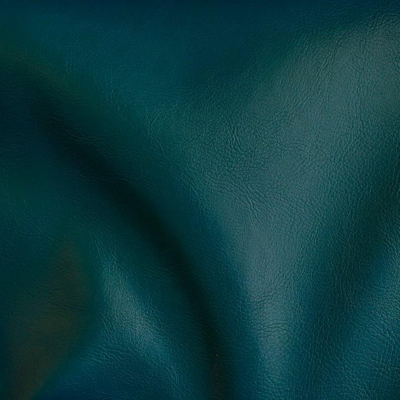 May include: A close-up of a teal leather fabric with a textured surface.