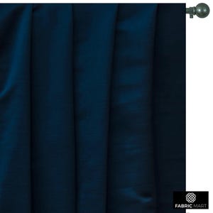 May include: A dark blue curtain panel with a subtle sheen. The curtain is hung on a silver curtain rod with a finial.