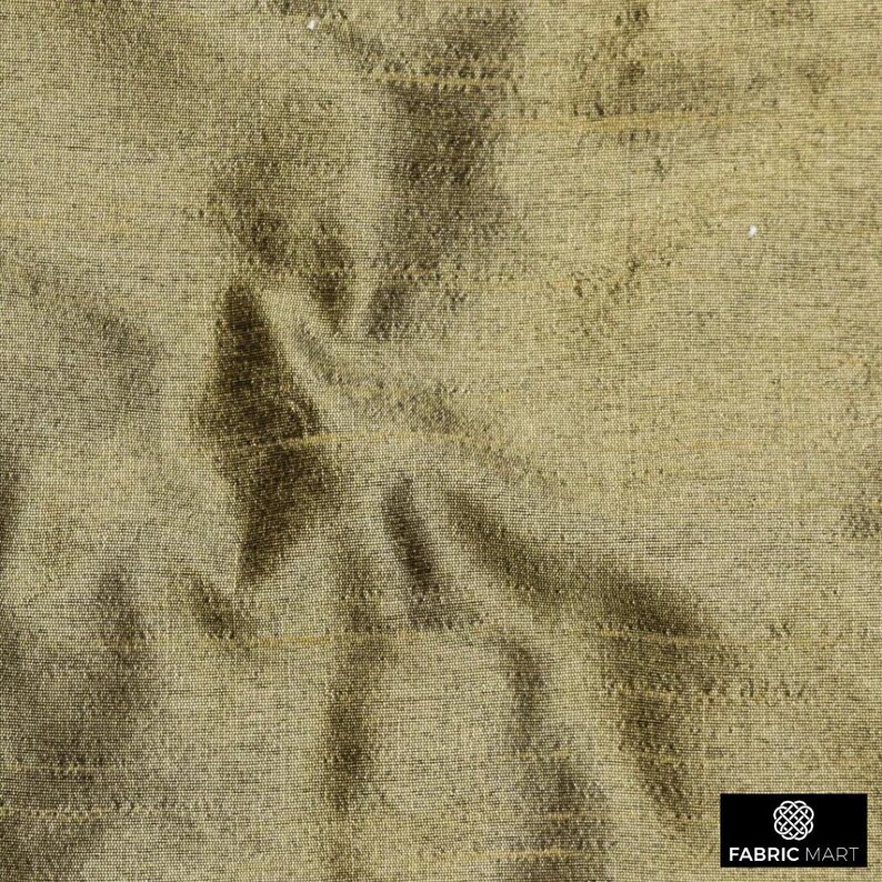 May include: A close-up of a textured, woven fabric in a light brown color. The fabric has a subtle sheen and a slightly wrinkled appearance.