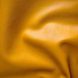 May include: A close-up of a textured, yellow fabric with a soft, wrinkled appearance.