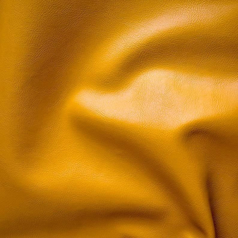 May include: A close-up of a textured, yellow fabric with a soft, wrinkled appearance.