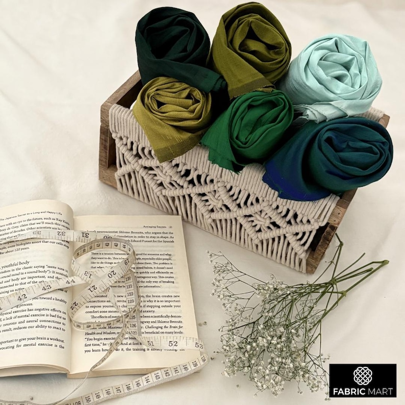 Puede incluir: Una colecci&oacute;n de seis cuadrados de tela coloridos en tonos de verde, azul y turquesa se muestran en una cesta de macram&eacute; tejida. La cesta est&aacute; hecha de fibras naturales y tiene un patr&oacute;n de diamante.