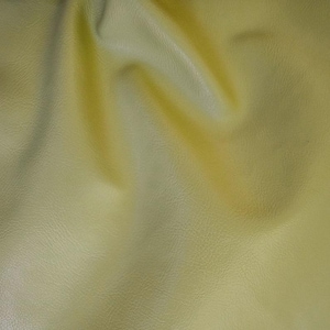 May include: A close-up of a textured, yellow fabric with a slight gradient from light to dark yellow.