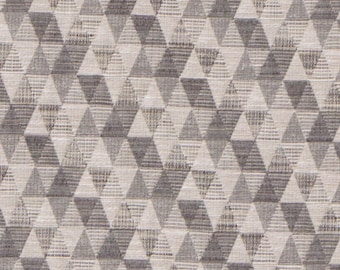 May include: A close-up of a fabric with a geometric pattern of gray and white triangles.