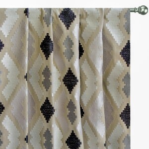 May include: Beige curtains with a geometric pattern of black, white, and gray diamonds.